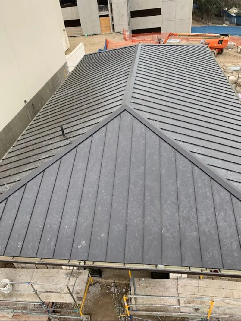 Commercial metal roof construction with crane equipment in Hadley